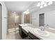 Main bathroom with double sinks, a walk-in shower, and a large mirror at 5110 Sylvester Loop, Tampa, FL 33610