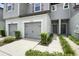 Exterior view of the townhome's entry, with manicured bushes along the walkway and a gray garage door at 5110 Sylvester Loop, Tampa, FL 33610