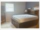 Bedroom with a bed, side table, and a window with blinds at 5541 Bay Blvd # 204, Port Richey, FL 34668