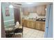 Compact kitchen featuring wood cabinets, white appliances, and a small dining table with chairs at 5541 Bay Blvd # 204, Port Richey, FL 34668