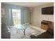 Cozy living room with a leather sofa, large window, and a television on the wall at 5541 Bay Blvd # 204, Port Richey, FL 34668