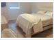 Bedroom with neutral walls and carpet; a dresser and comfortable bed at 5541 Bay Blvd # 303, Port Richey, FL 34668
