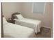 Cozy bedroom features carpet, a pair of twin beds, and neutral walls at 5541 Bay Blvd # 303, Port Richey, FL 34668