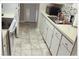 Galley kitchen features tile floor, sink, and ample cabinetry at 5541 Bay Blvd # 303, Port Richey, FL 34668
