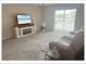 Living room features a comfy couch and sliding glass doors to screened porch at 5541 Bay Blvd # 303, Port Richey, FL 34668