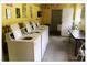 On-site shared laundry room with multiple washing machines and folding table at 5541 Bay Blvd # 310, Port Richey, FL 34668