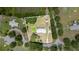Aerial view of the home with lush greenery, above ground pool and storage sheds at 5613 Forest Creek Rd, Lakeland, FL 33810