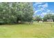 Large tree and backyard with a tire swing, storage shed and fenced in yard at 5613 Forest Creek Rd, Lakeland, FL 33810