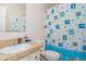 A bathroom with a sink, toilet, and a colorful shower curtain at 5613 Forest Creek Rd, Lakeland, FL 33810