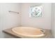 Clean bathroom showcasing a stylish, oval soaking tub and decorative window at 5613 Forest Creek Rd, Lakeland, FL 33810