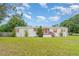 Charming single-story home featuring colorful accents, a cozy porch, and a sprawling front lawn at 5613 Forest Creek Rd, Lakeland, FL 33810