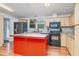 Bright kitchen with island, natural wood cabinets, black appliances, and a tiled backsplash at 5613 Forest Creek Rd, Lakeland, FL 33810