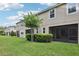 Backyard view of townhome, showing grass, small trees and enclosed porches at 5808 Grand Sonata Ave, Lutz, FL 33558