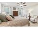 Well-lit bedroom featuring a patterned bedspread, ceiling fan, and bedside seating at 5808 Grand Sonata Ave, Lutz, FL 33558