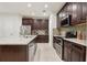 Gourmet kitchen featuring dark wood cabinets, granite countertops, and stainless steel appliances at 5808 Grand Sonata Ave, Lutz, FL 33558