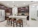 Modern kitchen island with seating, stainless steel appliances, and dark wood cabinetry at 5808 Grand Sonata Ave, Lutz, FL 33558