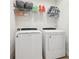 Efficient laundry room with modern washer and dryer, plus shelving for storage at 5808 Grand Sonata Ave, Lutz, FL 33558