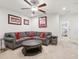 Comfortable living room featuring a large gray sectional sofa and ceiling fan at 5808 Grand Sonata Ave, Lutz, FL 33558
