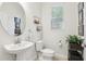 A simple powder room with a pedestal sink, toilet, and window with blinds at 5808 Grand Sonata Ave, Lutz, FL 33558