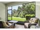 Relaxing screened porch with wicker furniture and view of lush green backyard at 5808 Grand Sonata Ave, Lutz, FL 33558