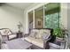 Inviting screened porch with seating, side tables and peaceful outdoor view at 5808 Grand Sonata Ave, Lutz, FL 33558