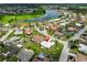 Stunning aerial view of a home near a lake, nestled in a vibrant community with a mix of colorful rooftops and lush greenery at 602 Deep Lake Ln, Sun City Center, FL 33573