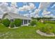 Beautifully landscaped backyard with lush green grass, mature shrubs, and a tiled roof at 602 Deep Lake Ln, Sun City Center, FL 33573