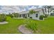 The backyard features lush green grass, mature shrubs and an attractive tile roof at 602 Deep Lake Ln, Sun City Center, FL 33573