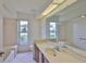 Bright bathroom featuring a large mirror, tiled floor, and a window providing natural light at 602 Deep Lake Ln, Sun City Center, FL 33573