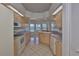 Well-lit kitchen with white appliances, light wood cabinets, tile floors, and a breakfast nook surrounded by windows at 602 Deep Lake Ln, Sun City Center, FL 33573