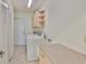 Well-lit laundry room with storage cabinets, washer, dryer, sink, and tiled floor at 602 Deep Lake Ln, Sun City Center, FL 33573