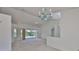 A bright and open living room with neutral carpet, a chandelier, and large sliding doors leading to the outdoors at 602 Deep Lake Ln, Sun City Center, FL 33573