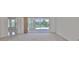 Bright living room view to sliding glass doors, neutral carpet and walls at 602 Deep Lake Ln, Sun City Center, FL 33573
