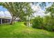 Scenic backyard with lush lawn extending to a peaceful pond and mature trees at 6044 Sandhill Ridge Dr, Lithia, FL 33547
