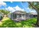 Enclosed lanai extends living space with a view of the manicured lawn and nearby trees at 6044 Sandhill Ridge Dr, Lithia, FL 33547