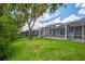 Beautiful backyard featuring a well-maintained lawn, enclosed lanais, and lush landscaping at 6044 Sandhill Ridge Dr, Lithia, FL 33547