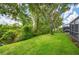 Lush backyard view featuring a pond, established trees, and manicured lawn near the home at 6044 Sandhill Ridge Dr, Lithia, FL 33547