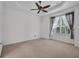 Cozy bedroom with ceiling fan, neutral carpeting, and a window with decorative curtains at 6044 Sandhill Ridge Dr, Lithia, FL 33547