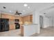 Bright kitchen featuring wood cabinets, black appliances, and a breakfast bar at 6044 Sandhill Ridge Dr, Lithia, FL 33547