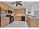 Updated kitchen featuring black appliances, a gas stove, and ample cabinet space for storage at 6044 Sandhill Ridge Dr, Lithia, FL 33547