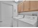 Functional laundry area with washer, dryer, cabinetry for storage, and a utility closet at 6044 Sandhill Ridge Dr, Lithia, FL 33547