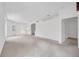 Open-concept living area with neutral carpet, white walls, and an arched opening to adjacent room at 6044 Sandhill Ridge Dr, Lithia, FL 33547