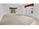 Bright living room features plush carpeting, large windows, and sliding glass doors to the lanai at 6044 Sandhill Ridge Dr, Lithia, FL 33547