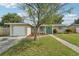 Charming home featuring a well-manicured lawn and a pop of color with a vibrant turquoise front door at 6167 31St Ave, St Petersburg, FL 33710