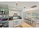Open concept kitchen with white appliances and cabinetry flowing into the dining area with wood floors at 6167 31St Ave, St Petersburg, FL 33710