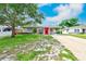Charming single-story home featuring a well-maintained lawn and a vibrant red front door at 6237 50Th N Ave, St Petersburg, FL 33709