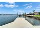 Waterfront view from private wooden dock with stairs into water, near well-kept houses and green lawns at 6334 Cocoa Ln, Apollo Beach, FL 33572