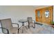 Covered front porch with double doors, a brick accent wall, and a table with two chairs at 6334 Cocoa Ln, Apollo Beach, FL 33572