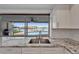 Kitchen area featuring granite countertops, a stainless steel sink, and a scenic view of the outdoor pool at 6334 Cocoa Ln, Apollo Beach, FL 33572