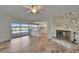 Open living room featuring a stone fireplace, light wood floors, and water views at 6334 Cocoa Ln, Apollo Beach, FL 33572